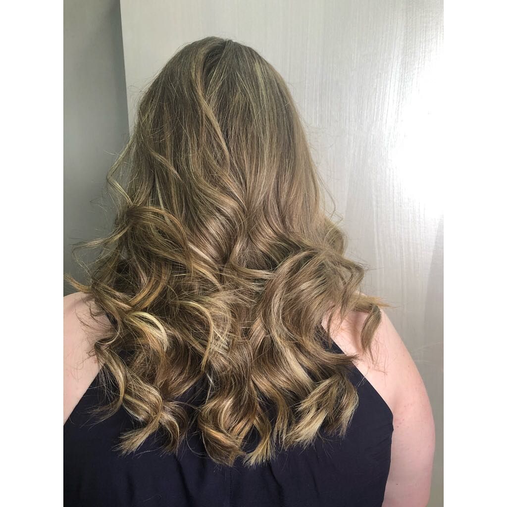 A Woman with Long Wavy Blonde Hair Is Wearing a Black Tank Top — Hair It Is In Balgownie, NSW
