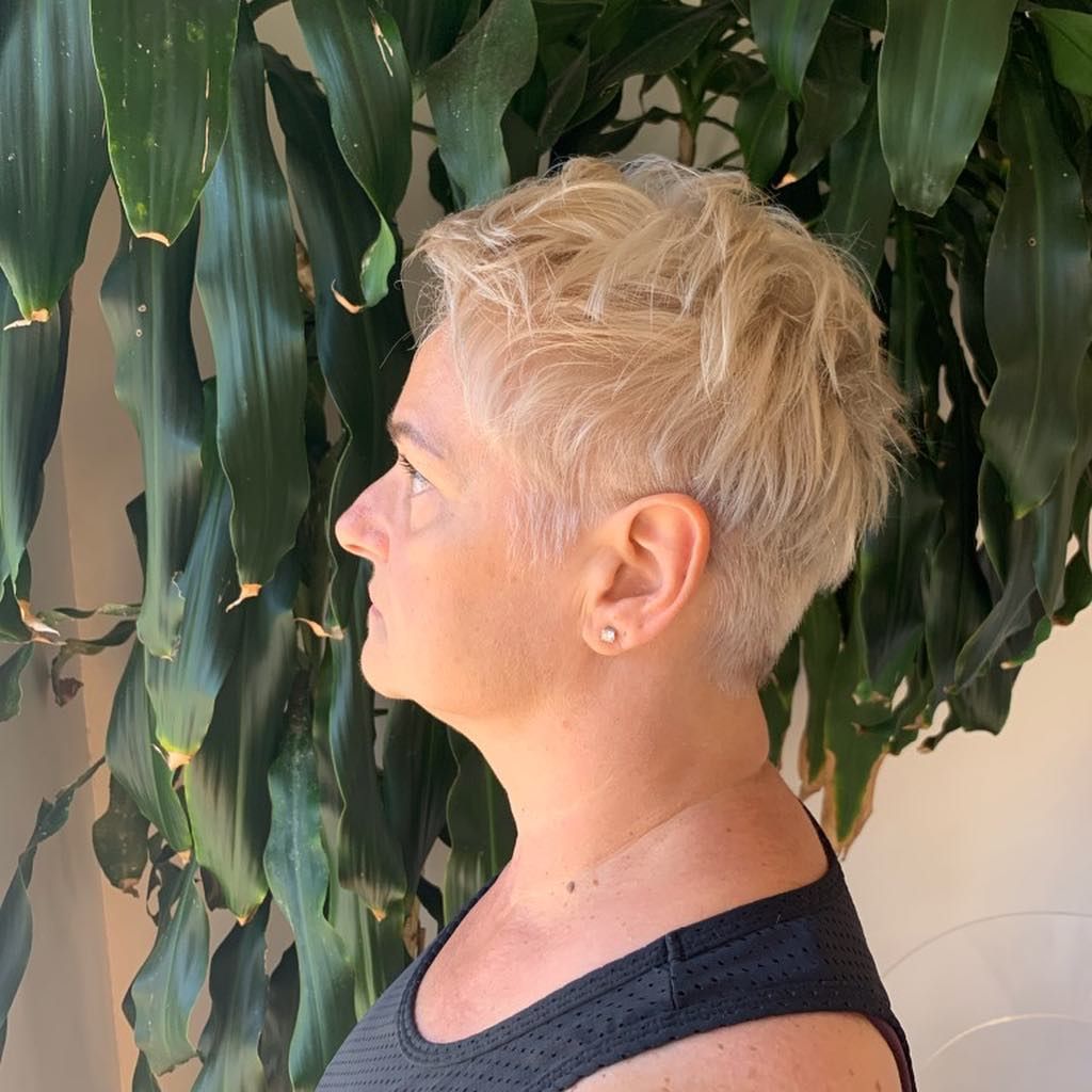 A Woman with Short Blonde Hair Is Standing in Front of A Plant — Hair It Is In Balgownie, NSW