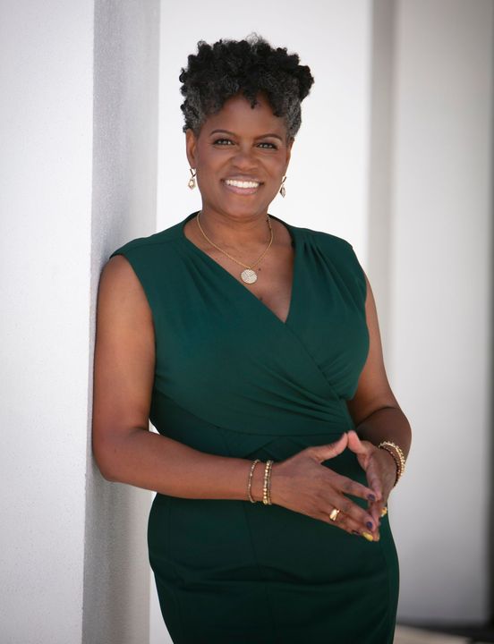 A woman in a green dress is leaning against a wall and smiling. | Riverview, FL | Renee Scott Insurance A woman in a green dress is leaning against a wall and smiling. | Riverview, FL | Renee Scott Insurance