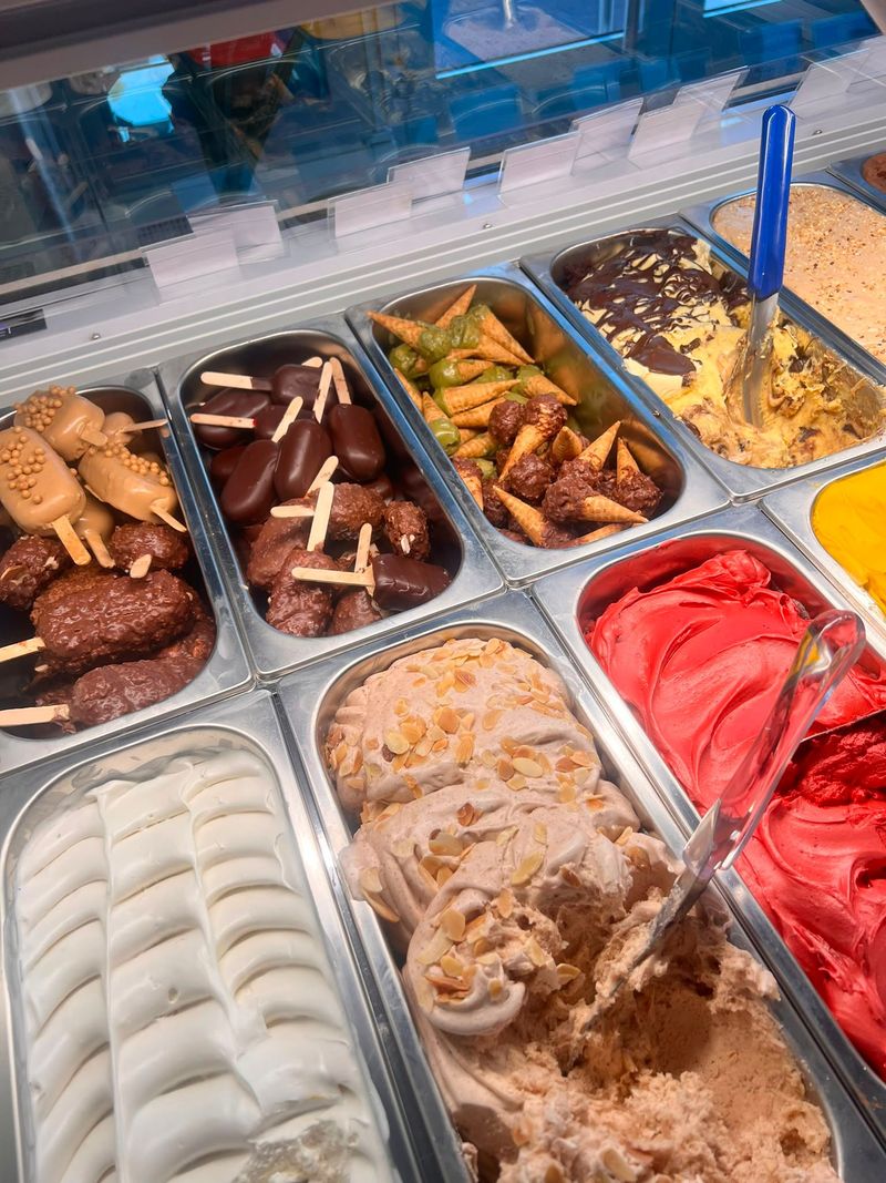 Vetrina da forno con assortimento di pasticcini, biscotti e crostate in vassoi di metallo.