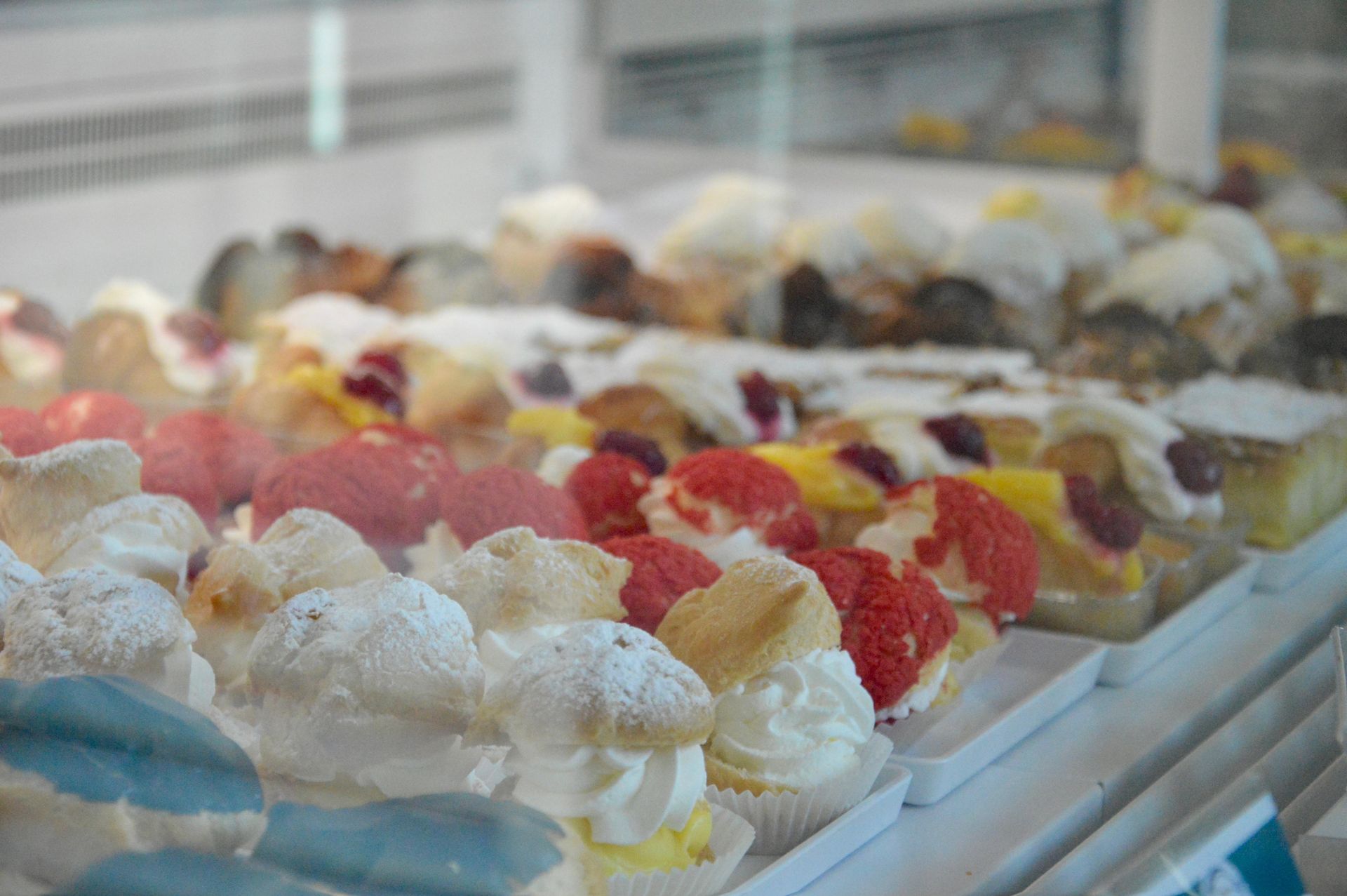 Vassoi di gelato o sorbetto colorati in una vetrina al bancone di un negozio.