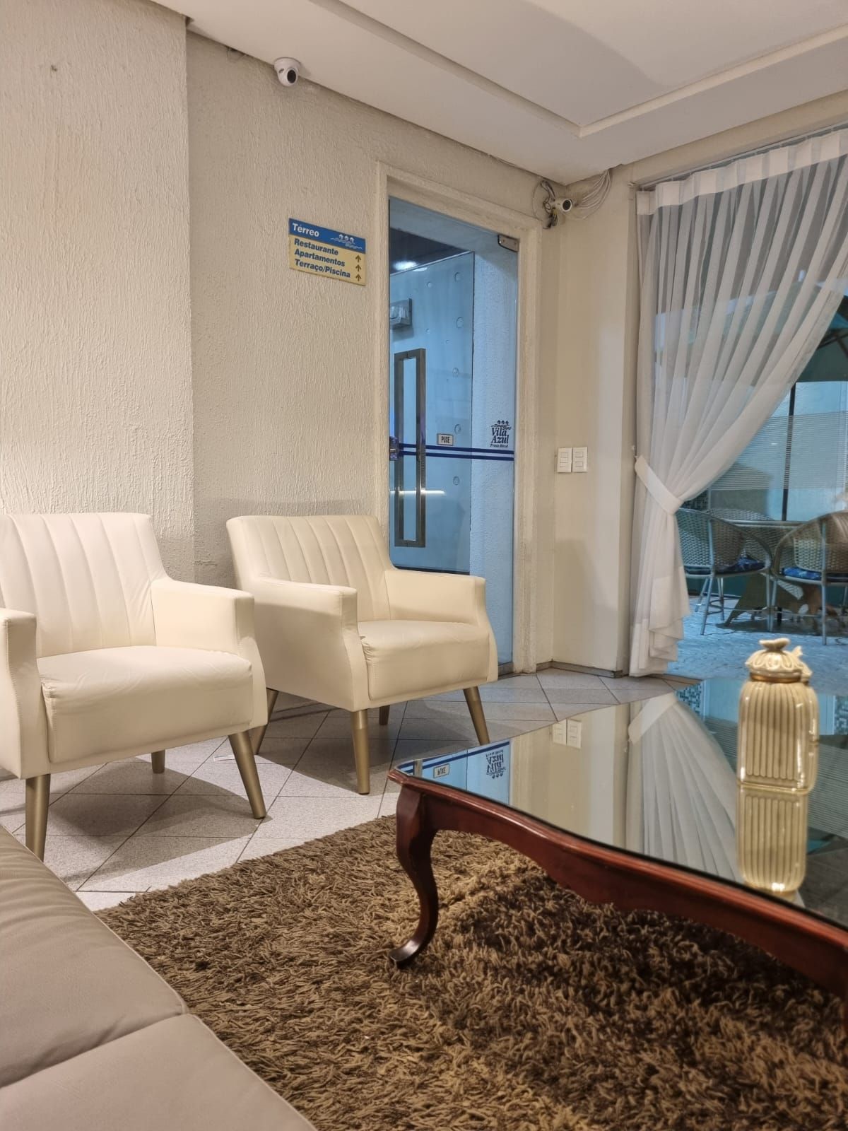 Uma sala de estar com duas cadeiras e uma mesa de centro Vila Azul Praia Hotel