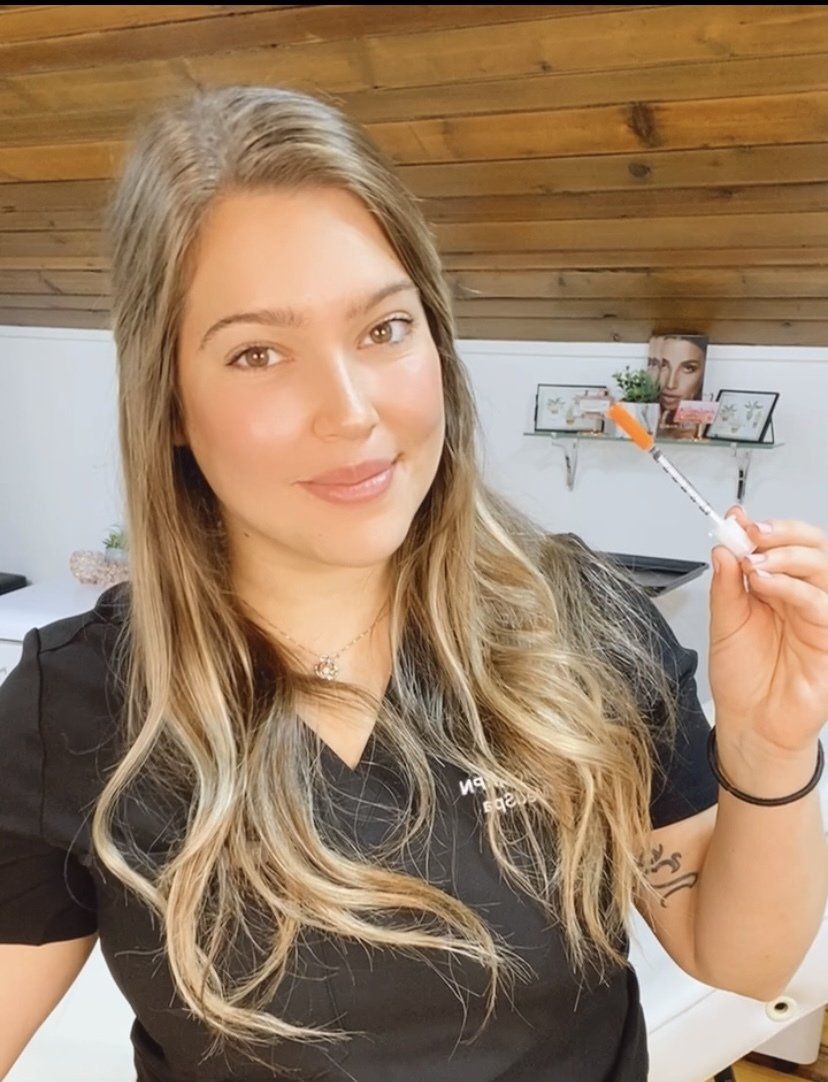 A woman in a black shirt is holding a brush in her hand.