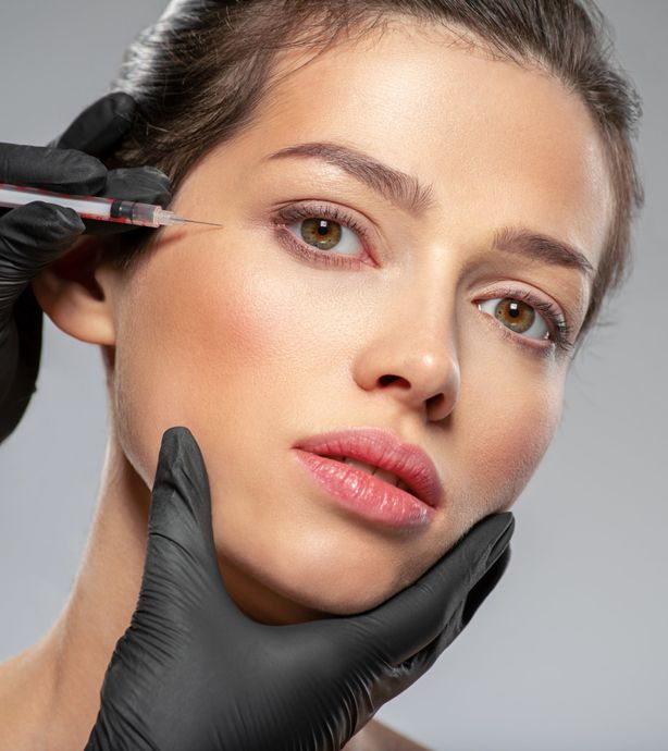 A woman is getting a botox injection in her eye.