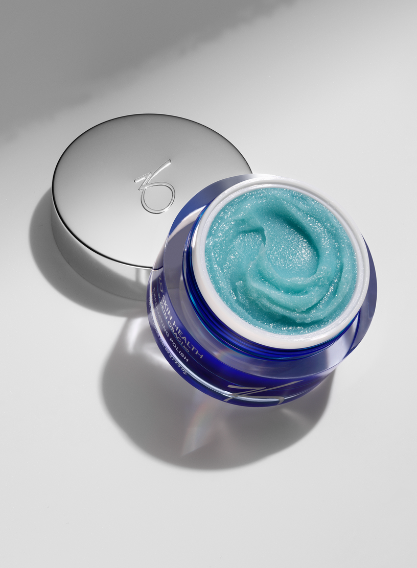 A blue jar of cream is sitting on a white surface.