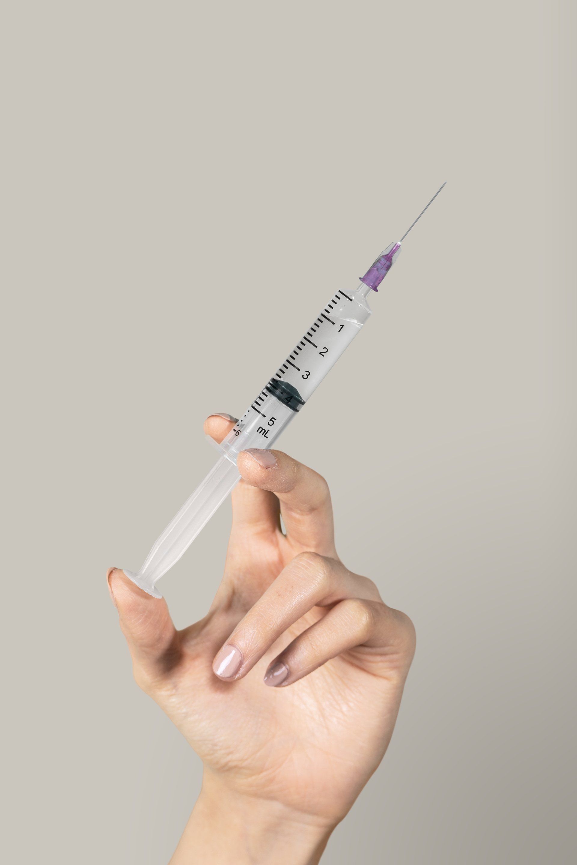A woman is holding a syringe in her hand.