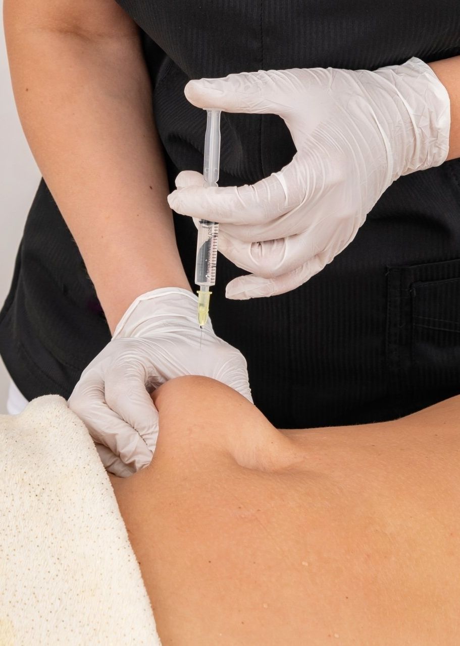 A woman is getting an injection in her arm.