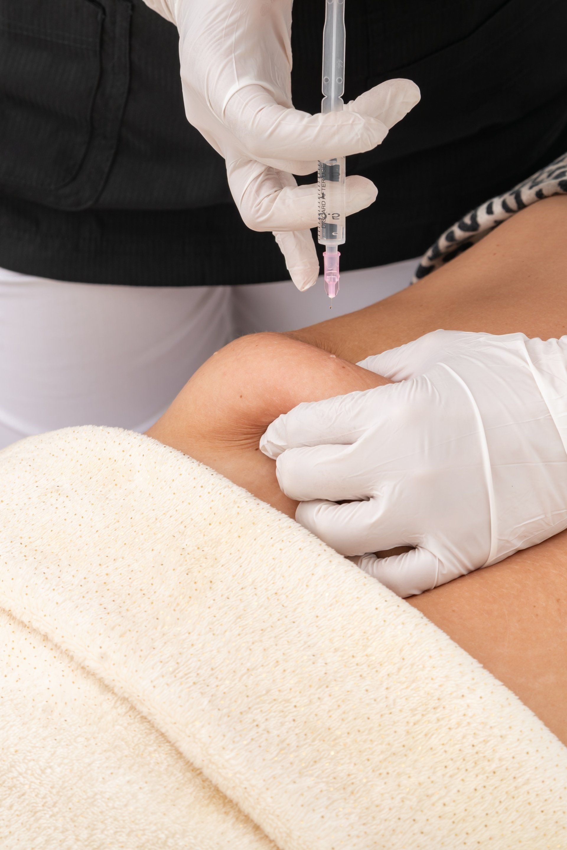 A woman is getting an injection in her knee