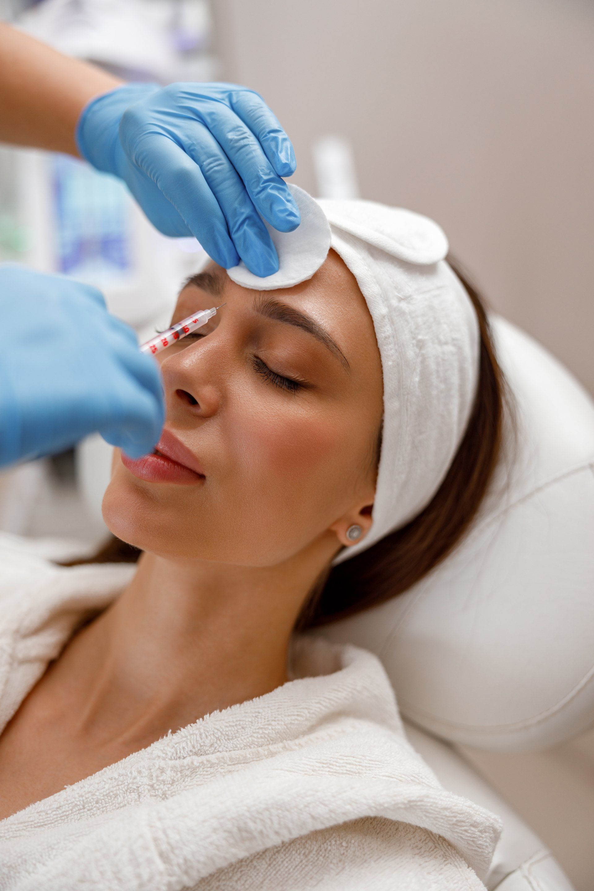 A woman is getting an injection in her face at a beauty salon.