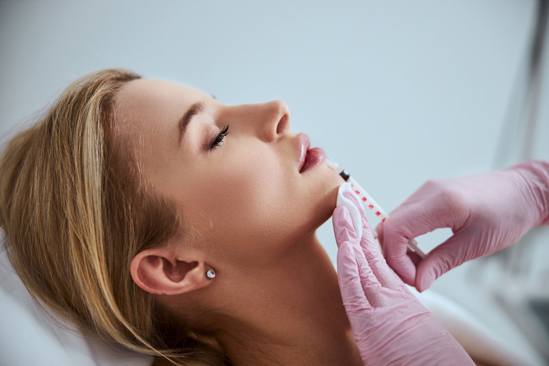 A woman is getting a botox injection in her neck.