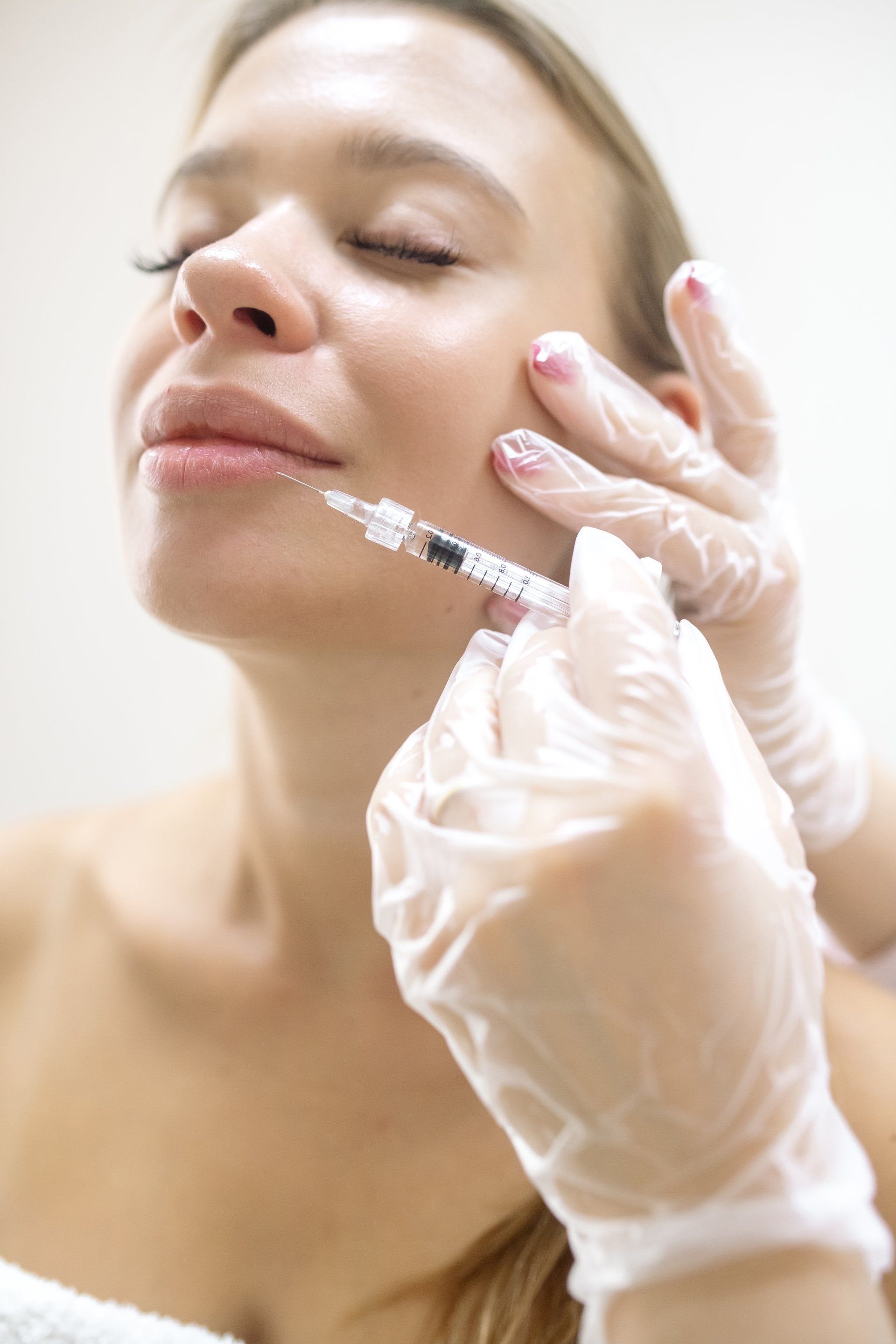 A woman is getting a botox injection in her face.