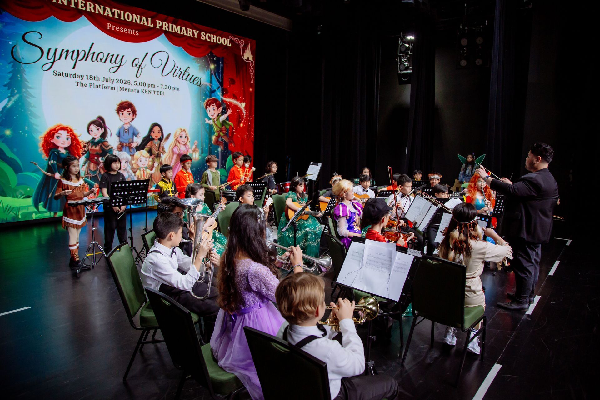 School orchestra performing on stage as part of a musical showcase titled “Symphony of Virtues