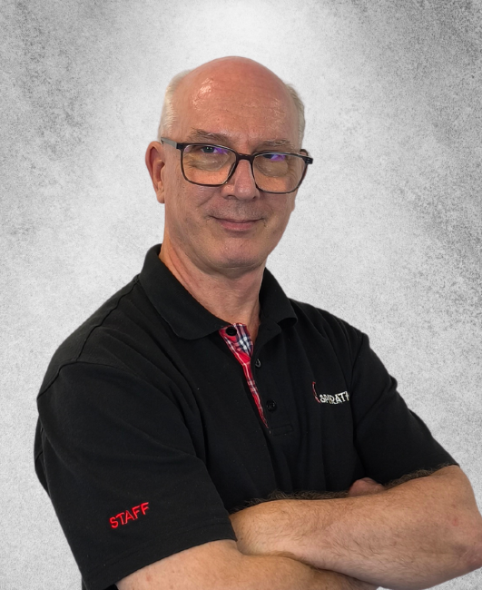 A person with glasses, wearing a black polo shirt with