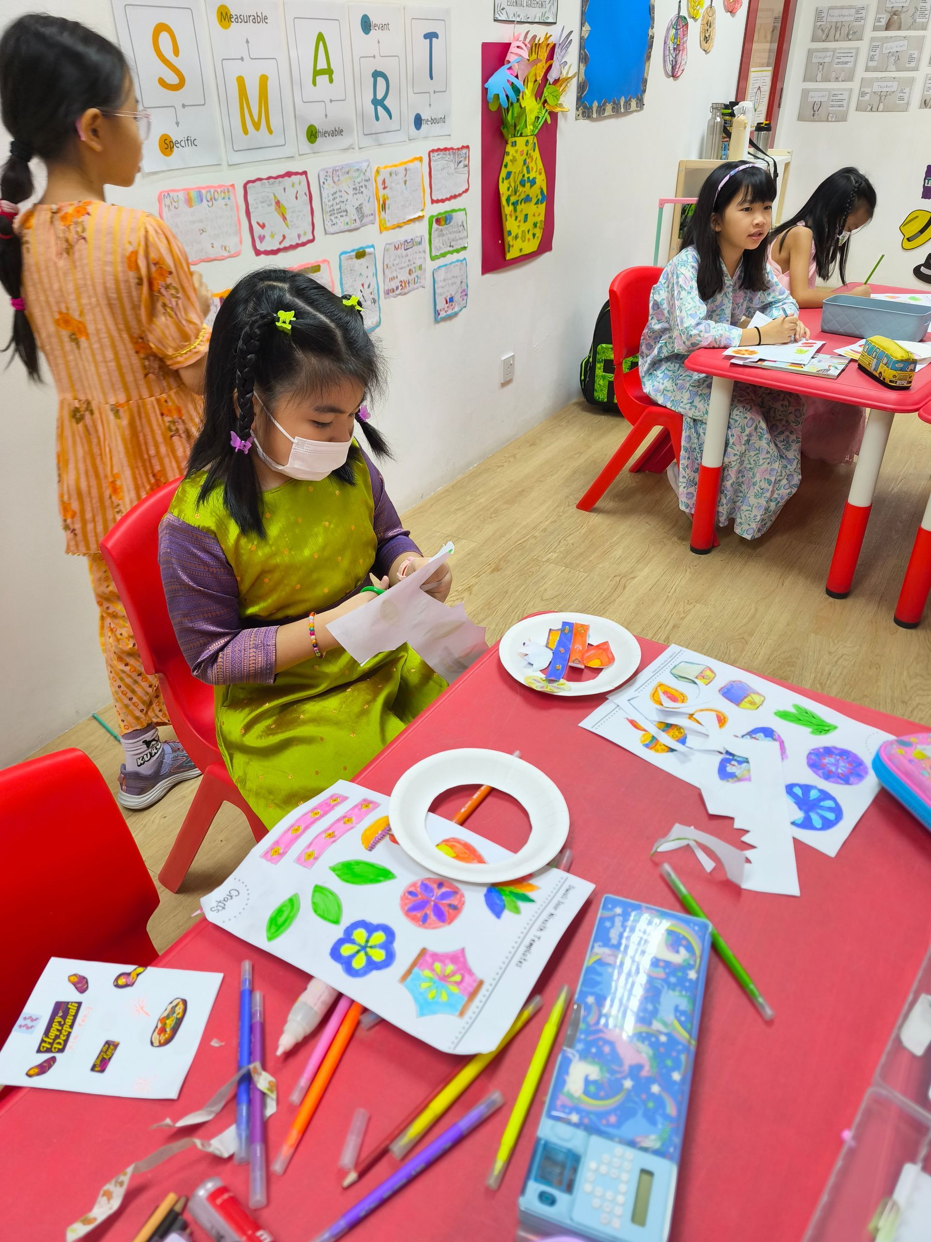 A group of students and teachers sitting on colorful tiered stairs inside a Ninja Park facility.