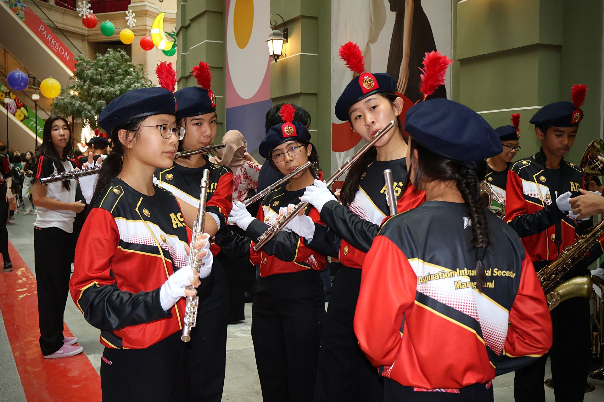 A group of five individuals practicing a synchronized music instrument for marching band.