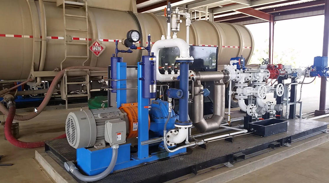 Industrial water treatment skid with blue pumps, pipes, and tanks in a factory setting