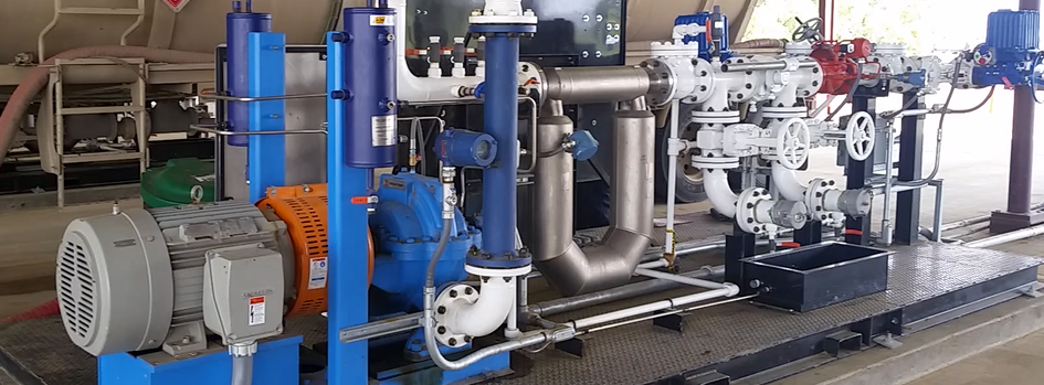 Industrial machinery with blue and gray pipes, motors, and equipment on a factory floor
