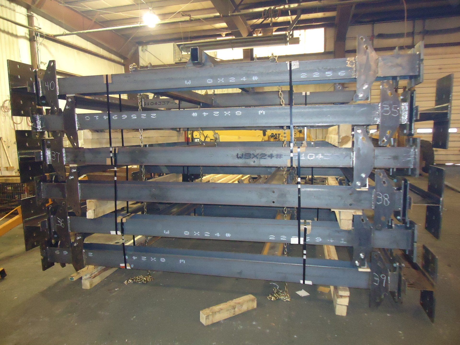 Stacked metal shelving frames in a warehouse or workshop, with tools and materials around them.