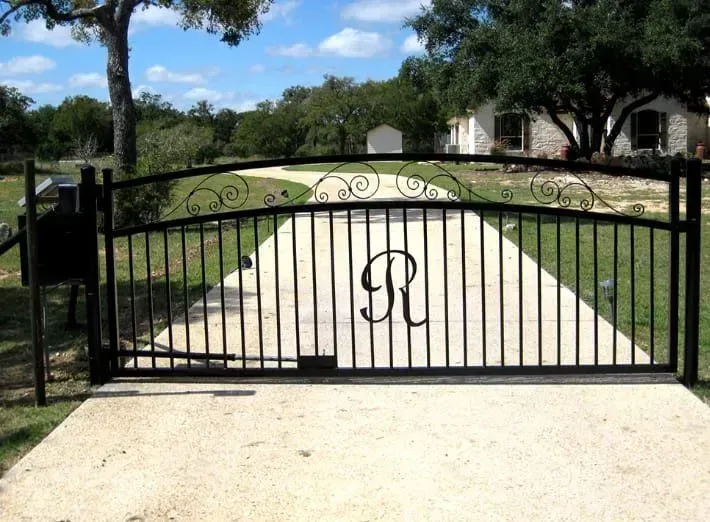 Black wrought iron gate with an ornate scroll design and large