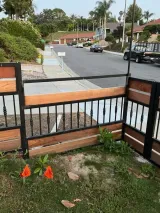 Fence with iron and metal detailing bordering a residential street.