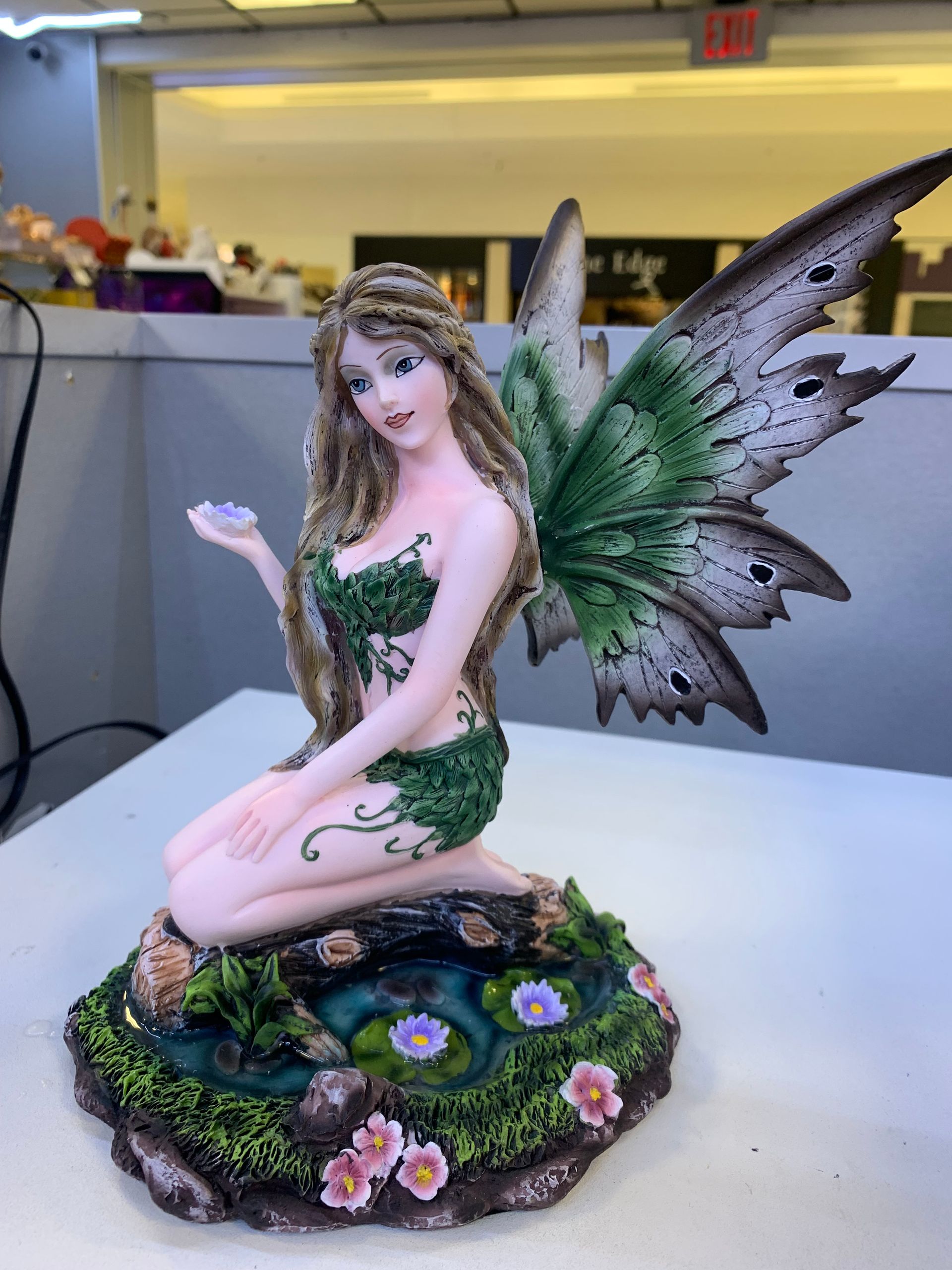 A statue of a fairy is sitting on a table