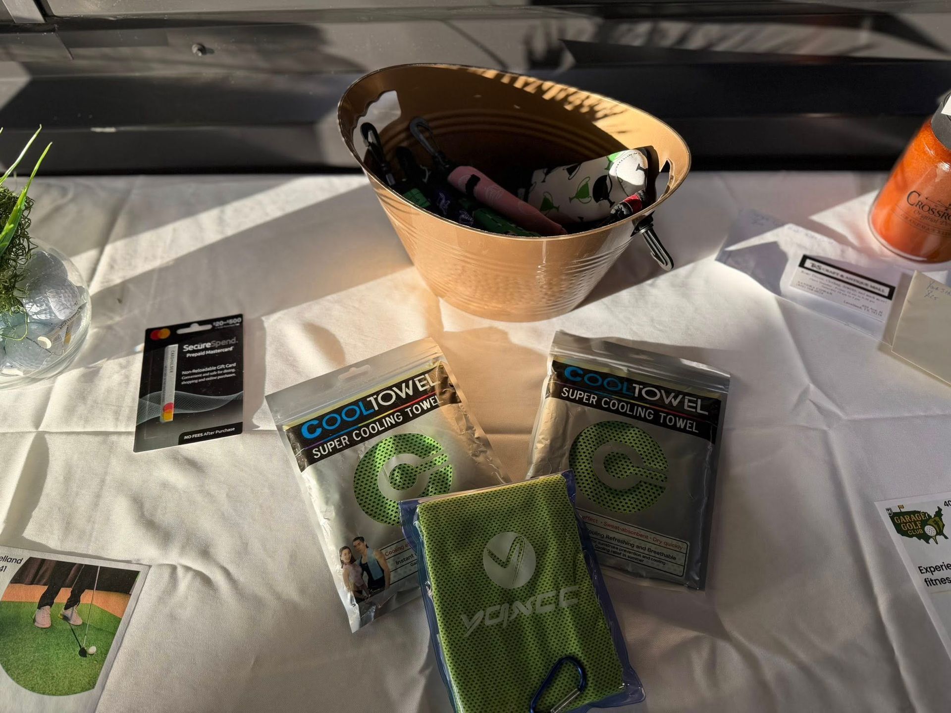 Table display with towels, basket of items, and other products, indoors with sunlight.