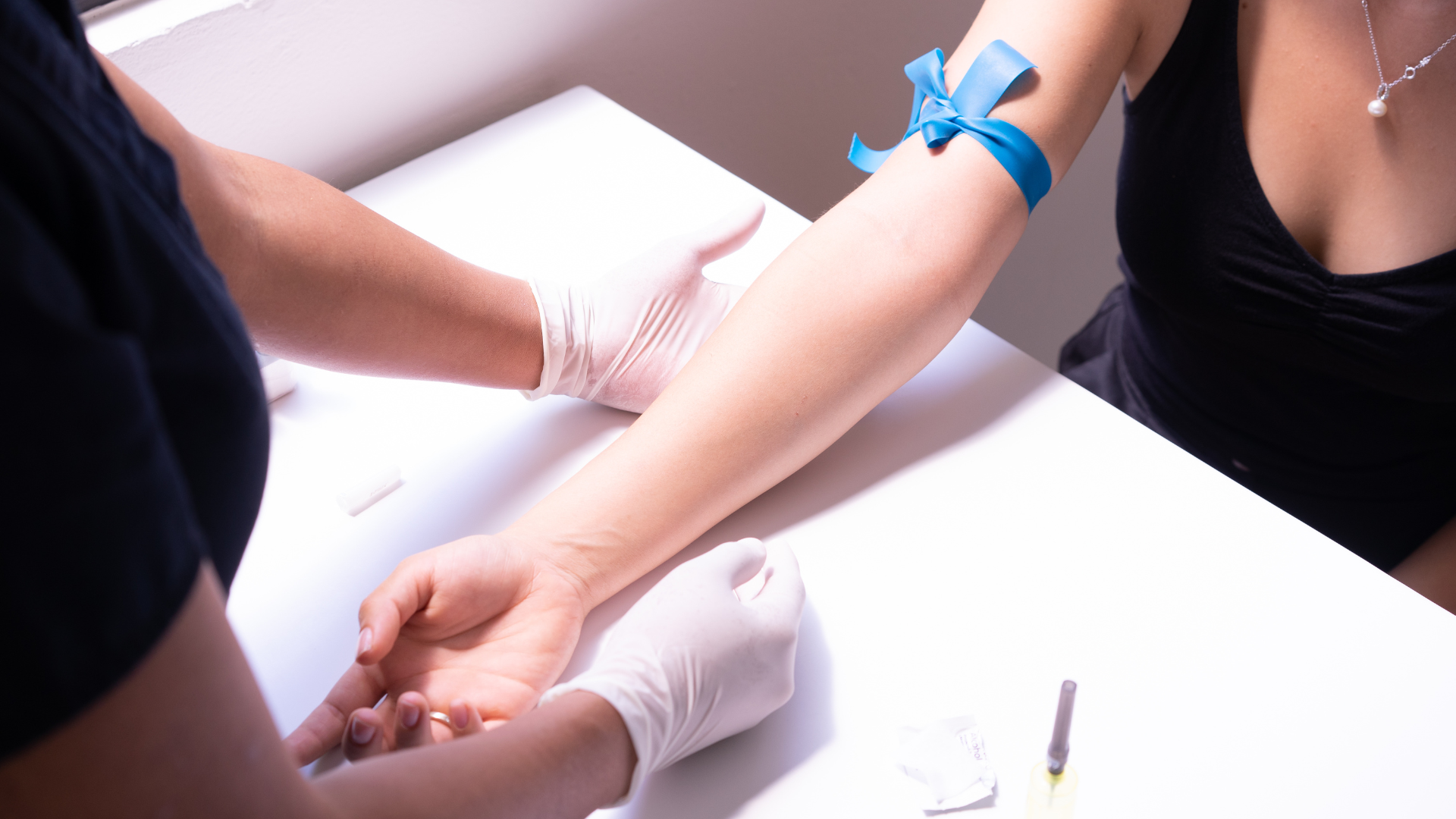 A woman receives an arm examination from a doctor in a clinical setting.
