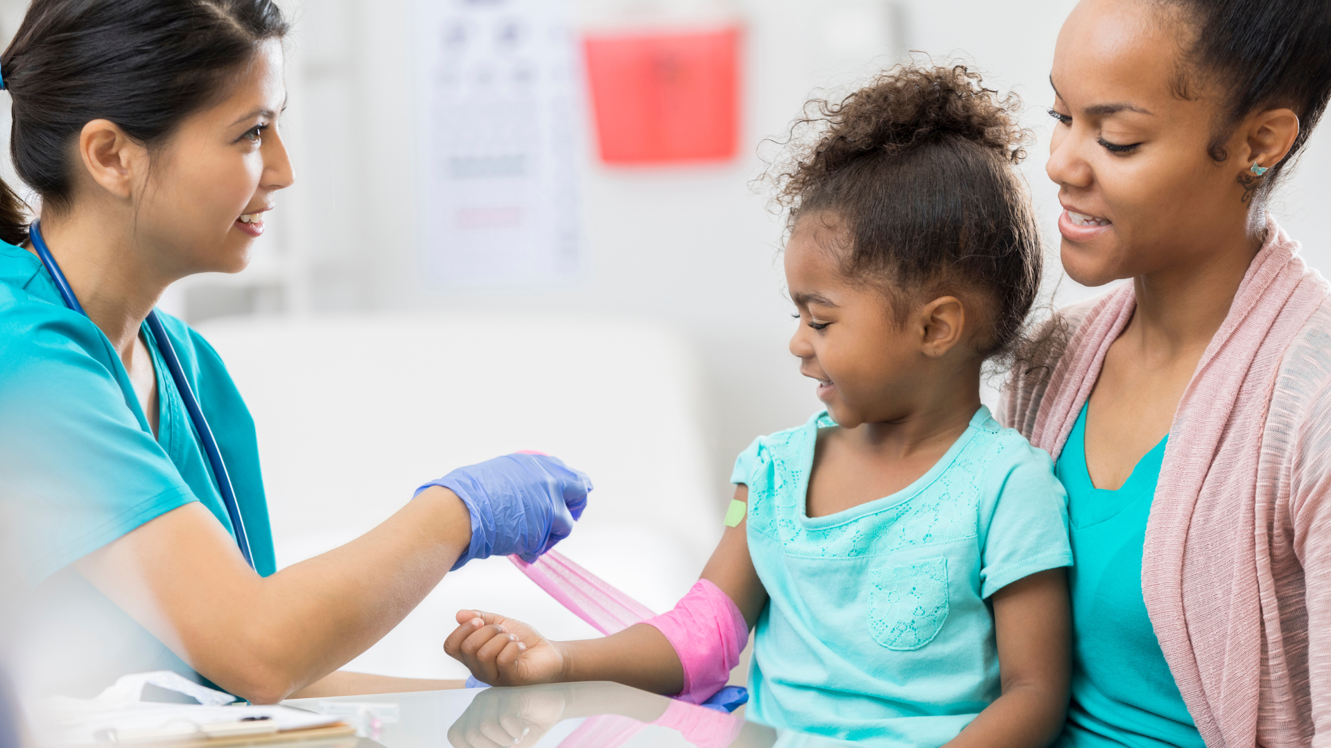 A little girl is getting her arm bandaged by a nurse.