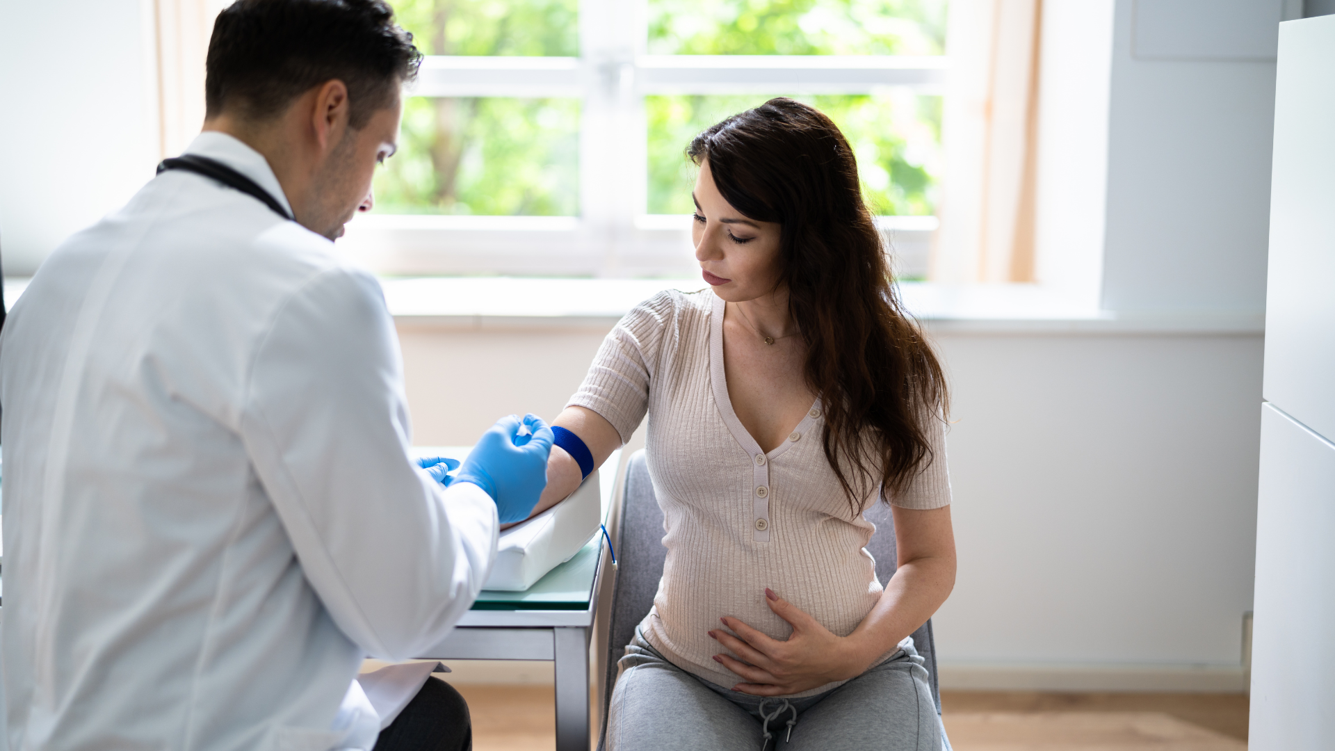 A doctor checks the blood pressure of a pregnant woman during a medical examination.