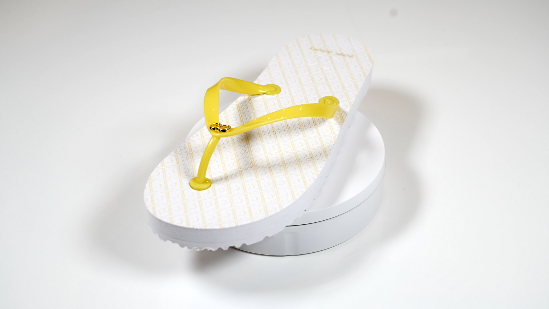 A pair of white flip flops with yellow straps