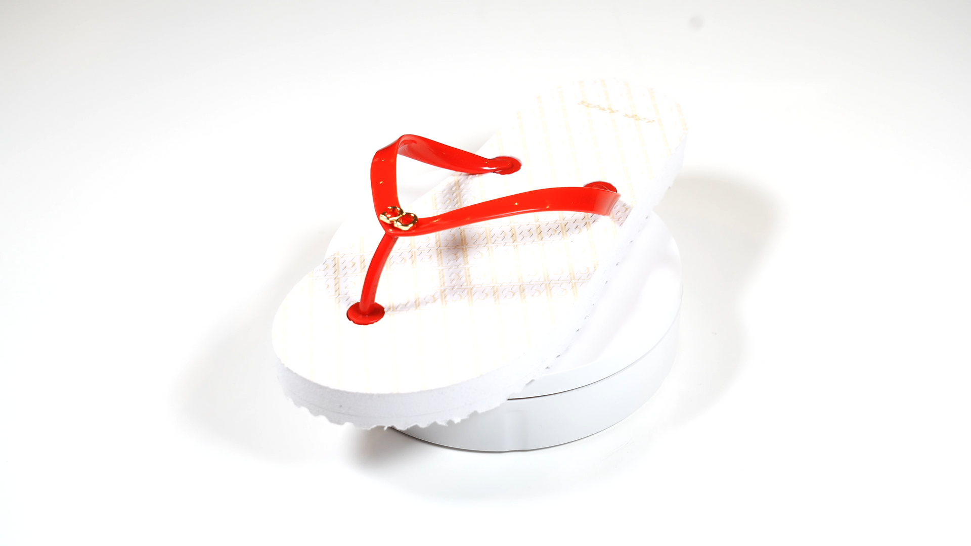 A pair of white flip flops with red straps