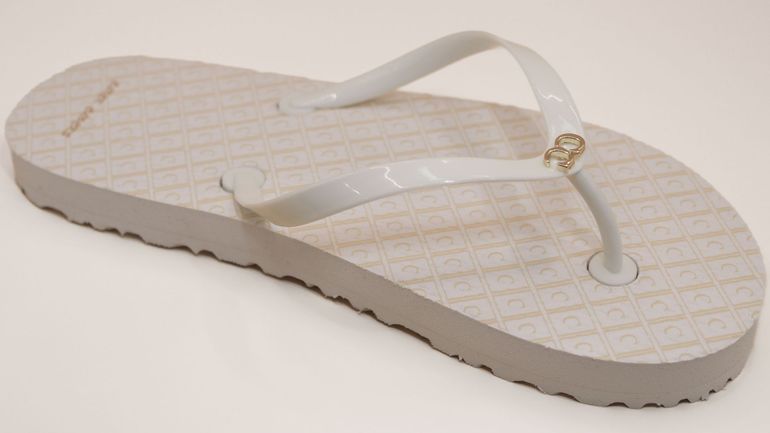 A pair of white flip flops on a white surface