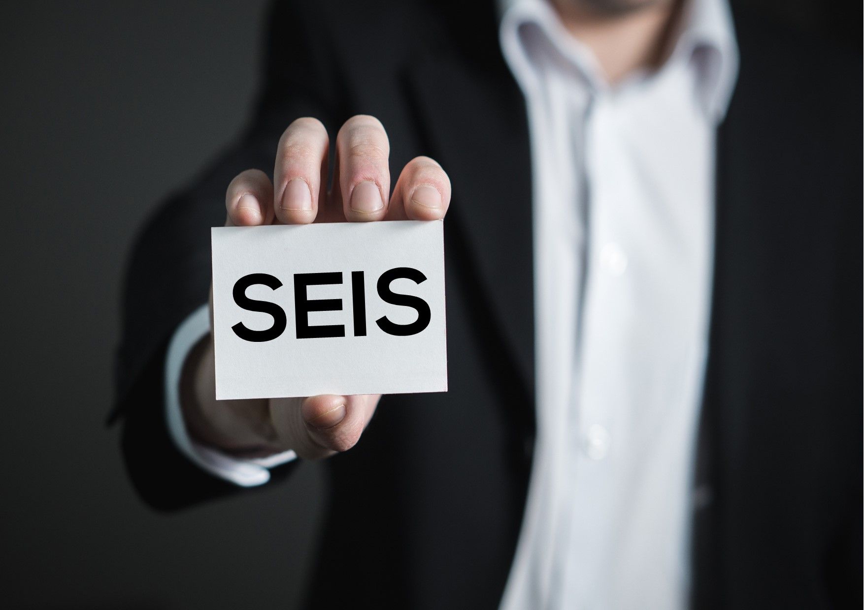 Man holding a card with the Letters SEIS