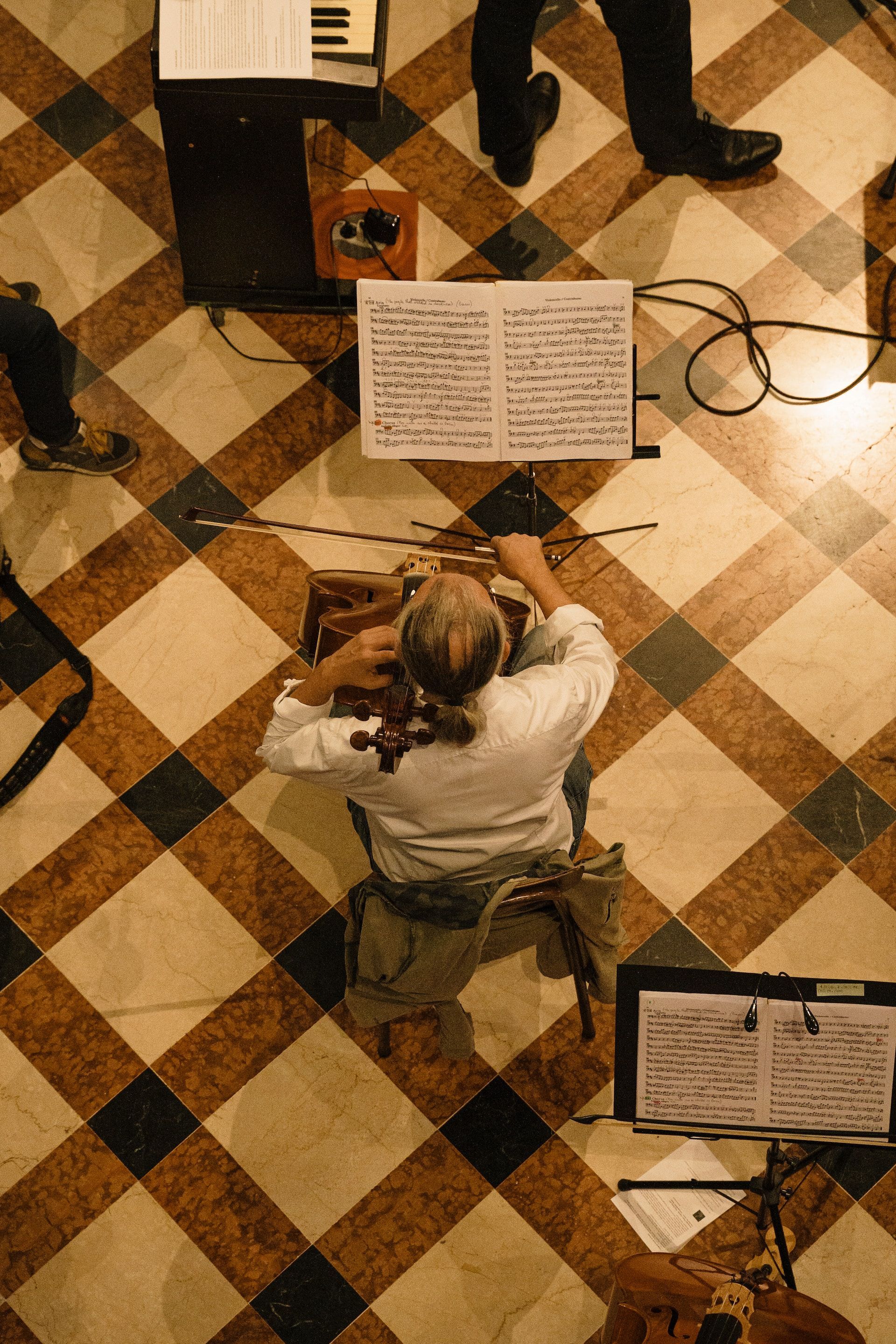 A man is kneeling down playing a violin