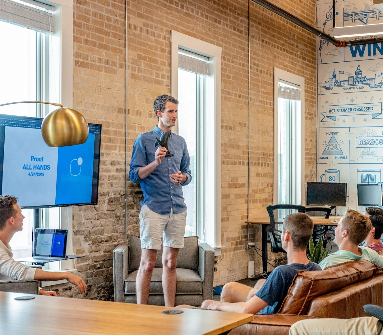 A man is giving a presentation to a group of people in a conference room.