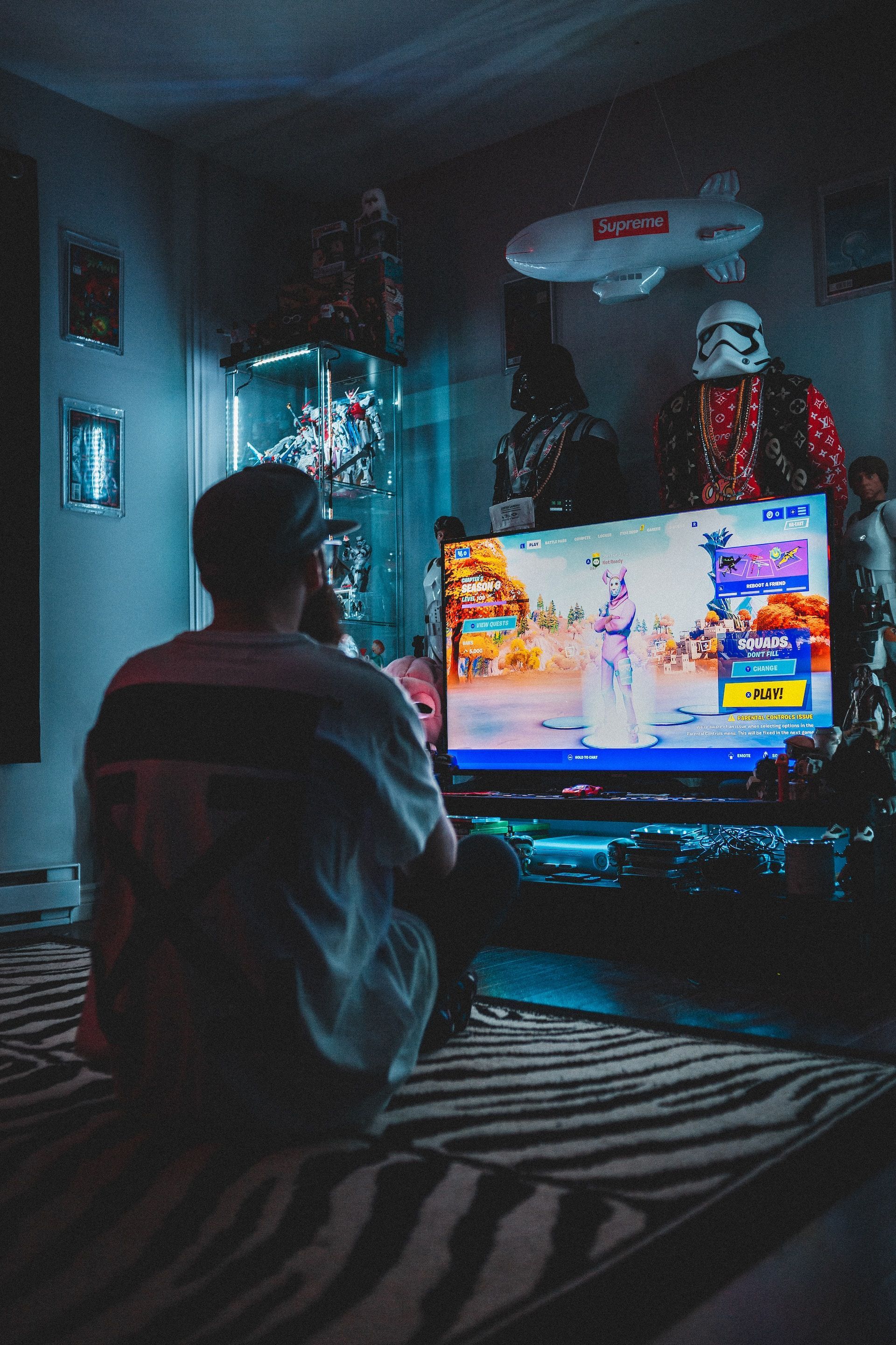 A man is sitting in front of a television playing a video game.