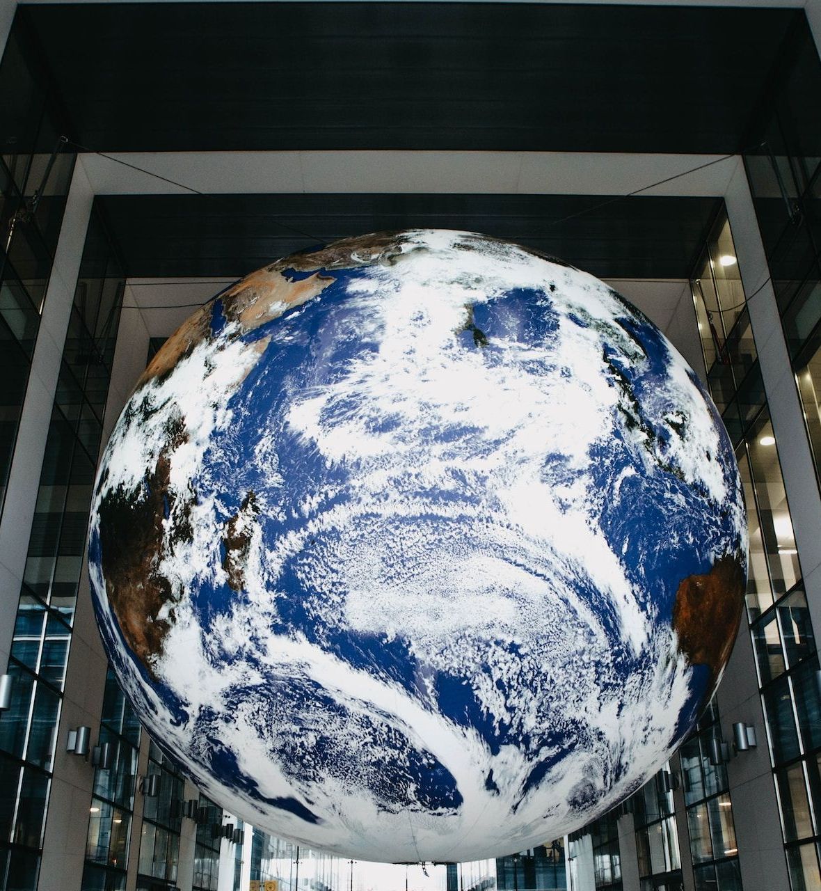 A large globe is hanging from the ceiling of a building