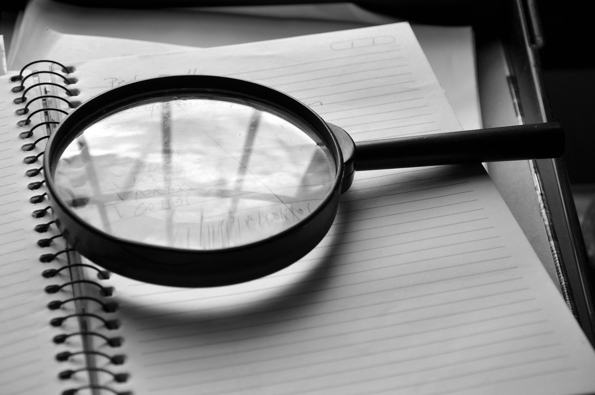 A magnifying glass is sitting on top of a notebook