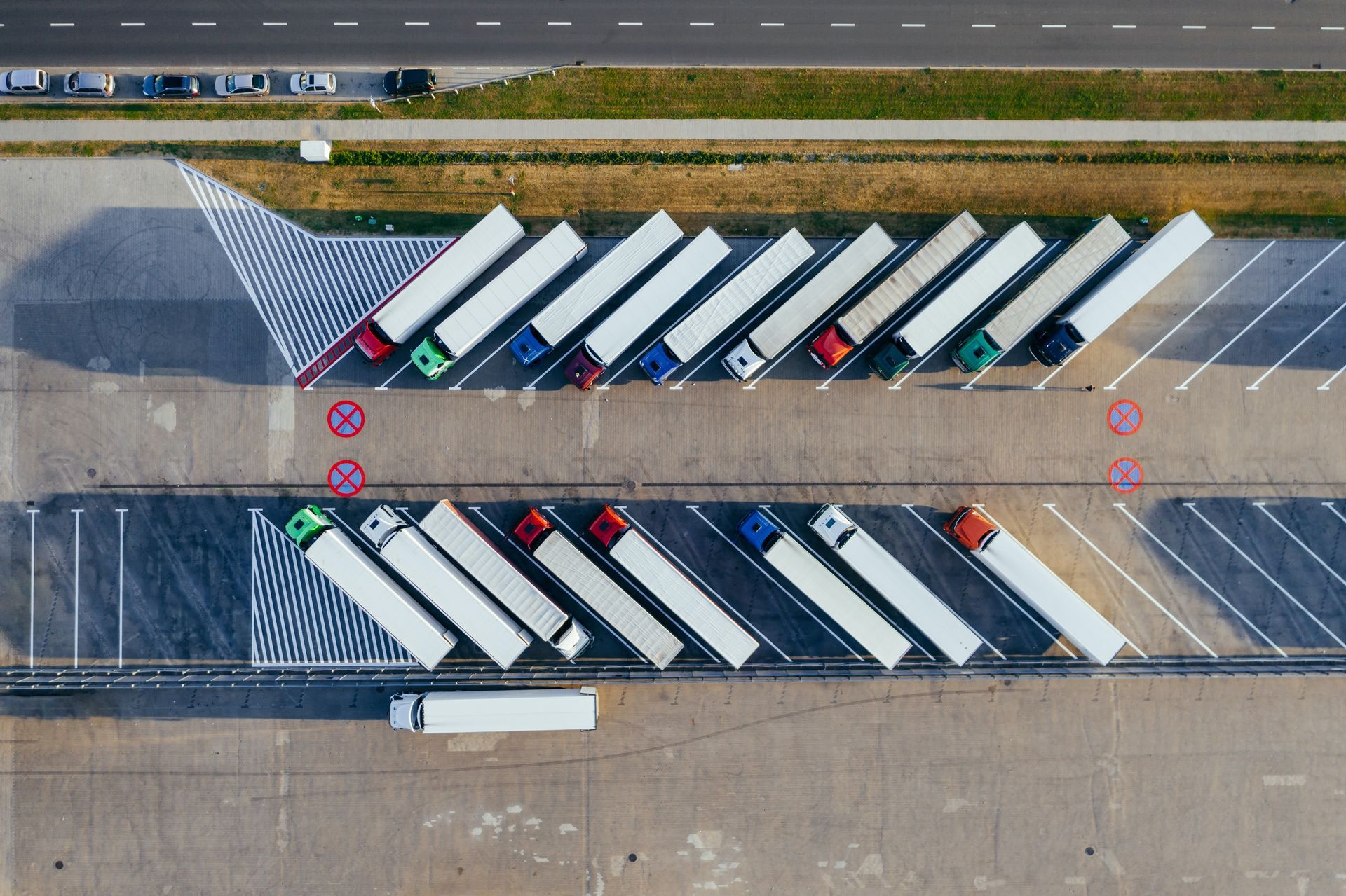 An aerial view of a row of trucks parked in a parking lot.