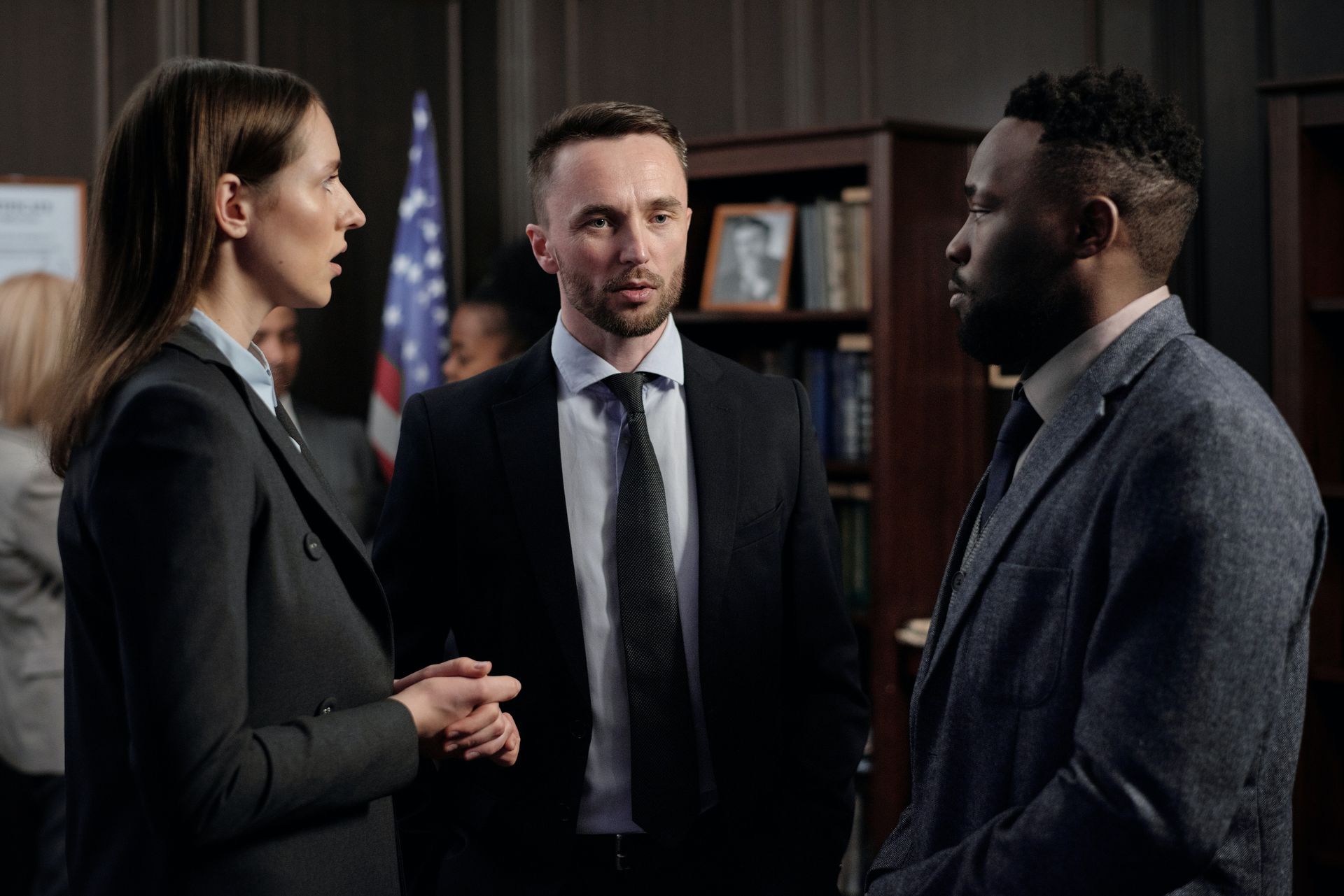 A group of people in suits and ties are talking to each other in a room.