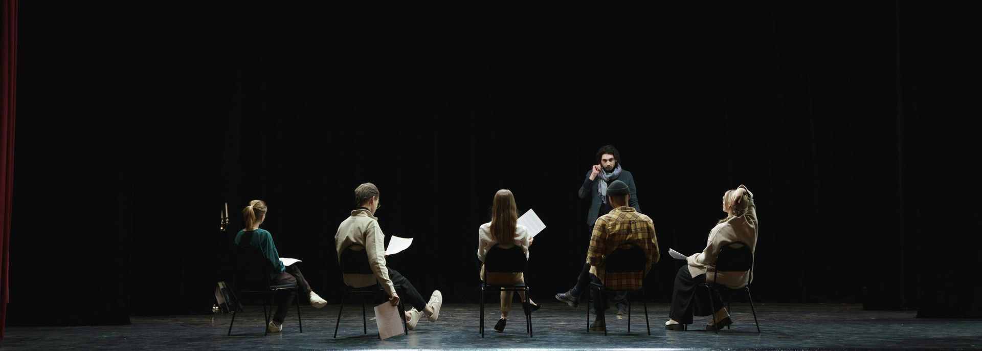A group of people are sitting in a circle on a stage.