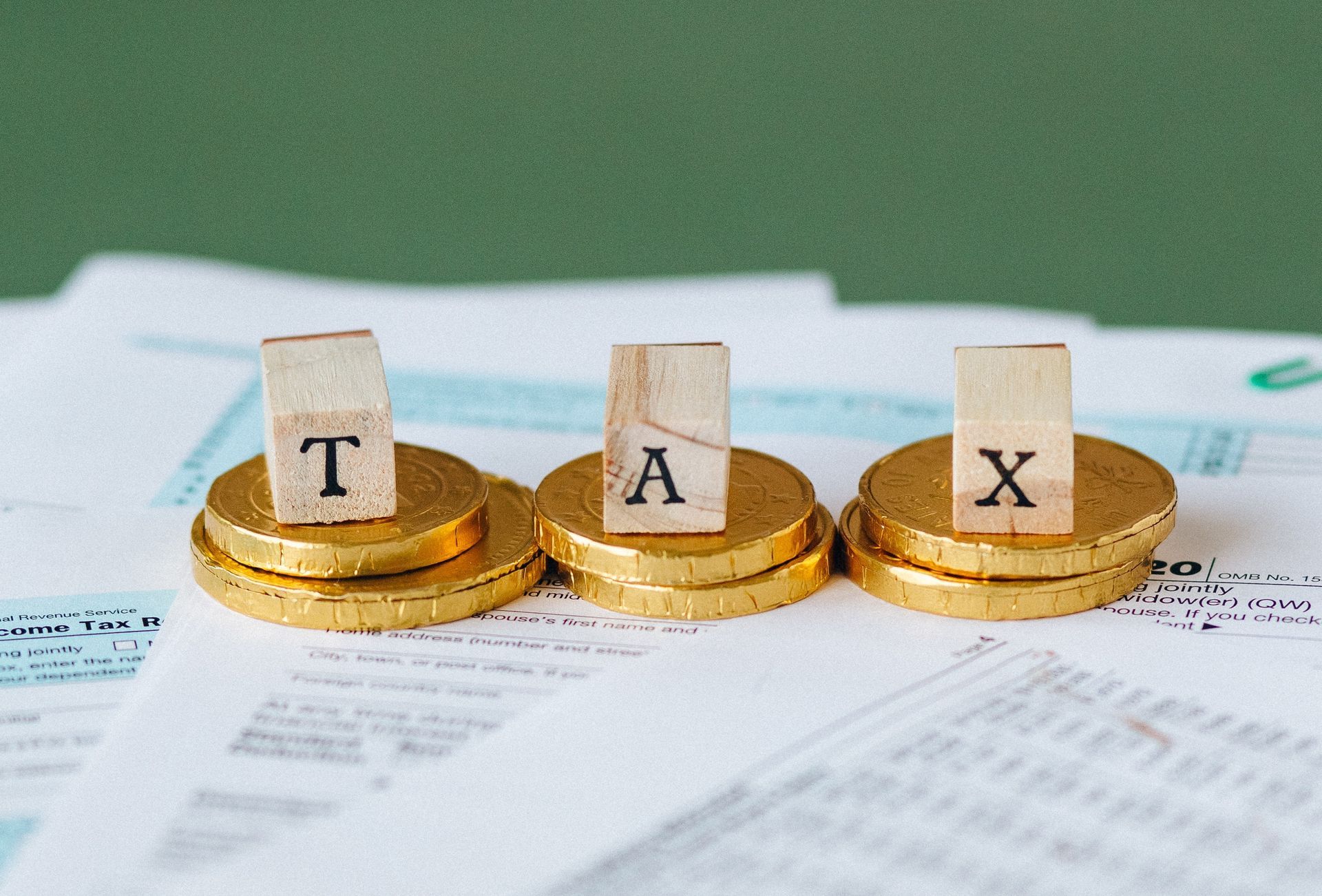 Three stacks of gold coins with the word tax written on them.