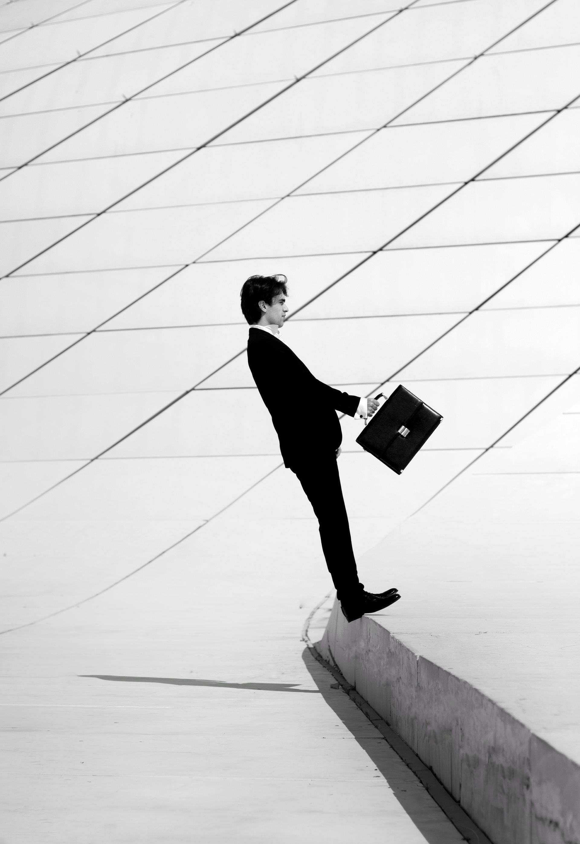 A black and white photo of a man holding a briefcase