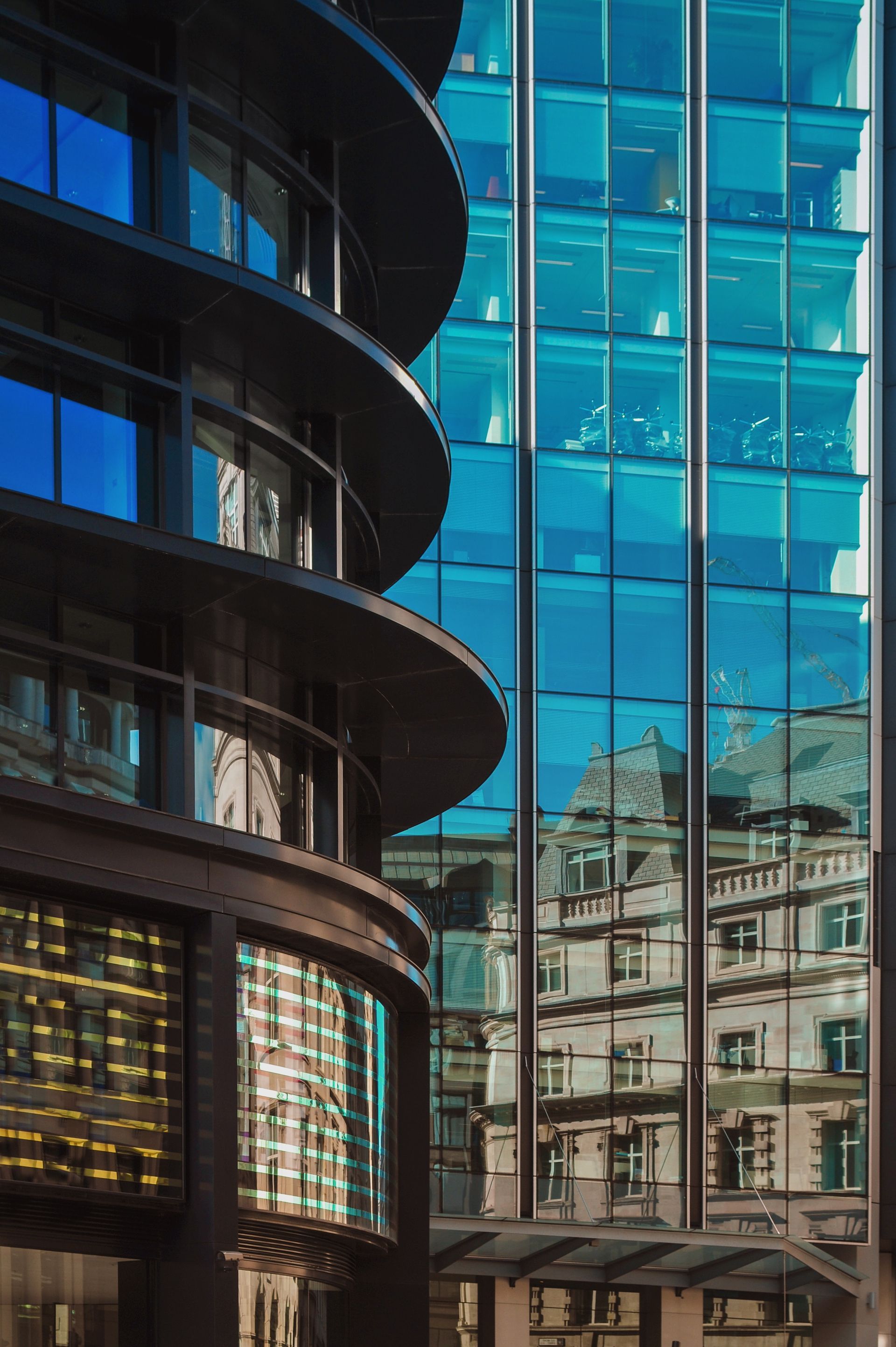 A building with a lot of windows and a reflection of another building in the windows.