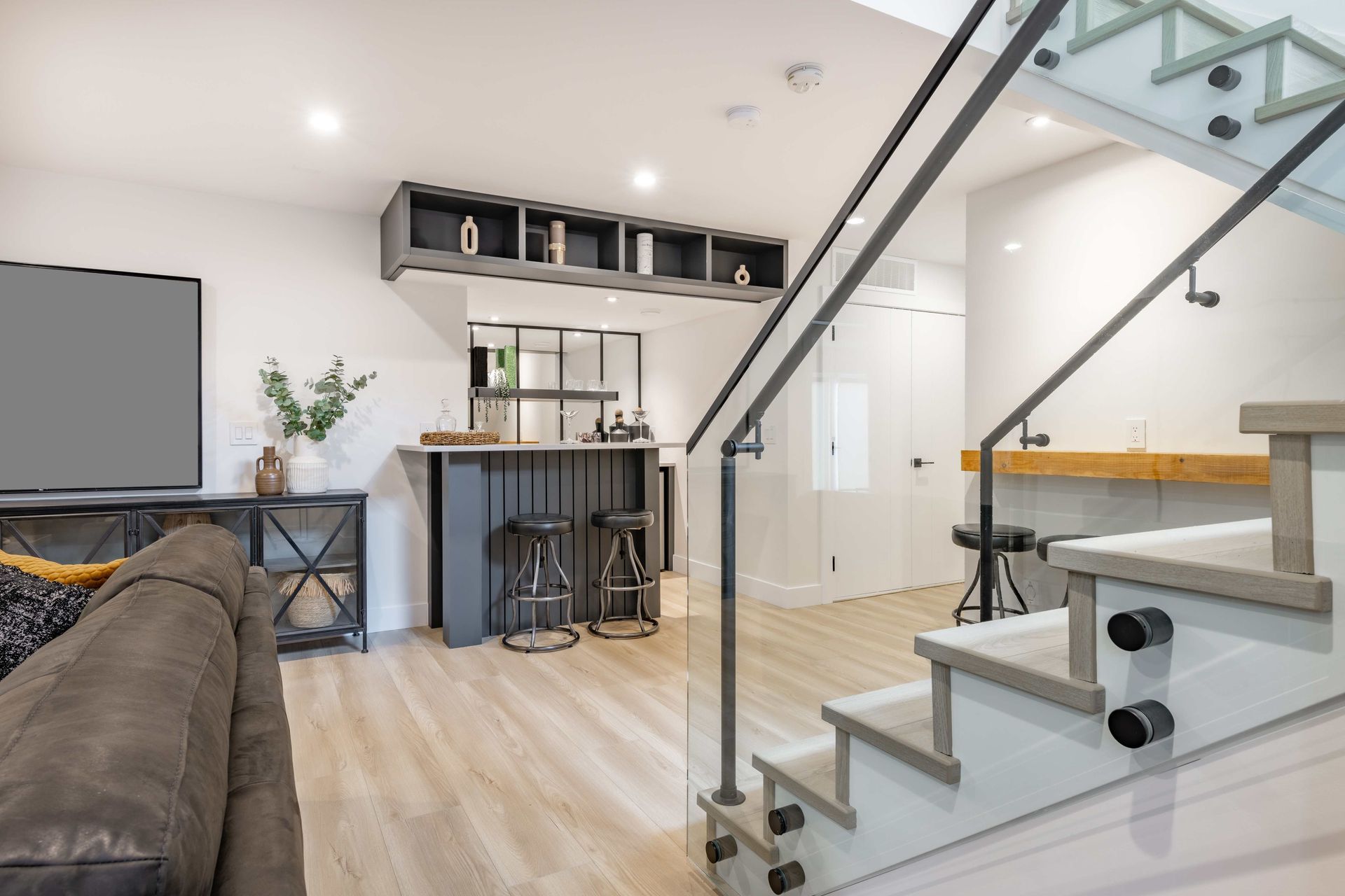 a living room with a couch and stairs leading up to the second floor