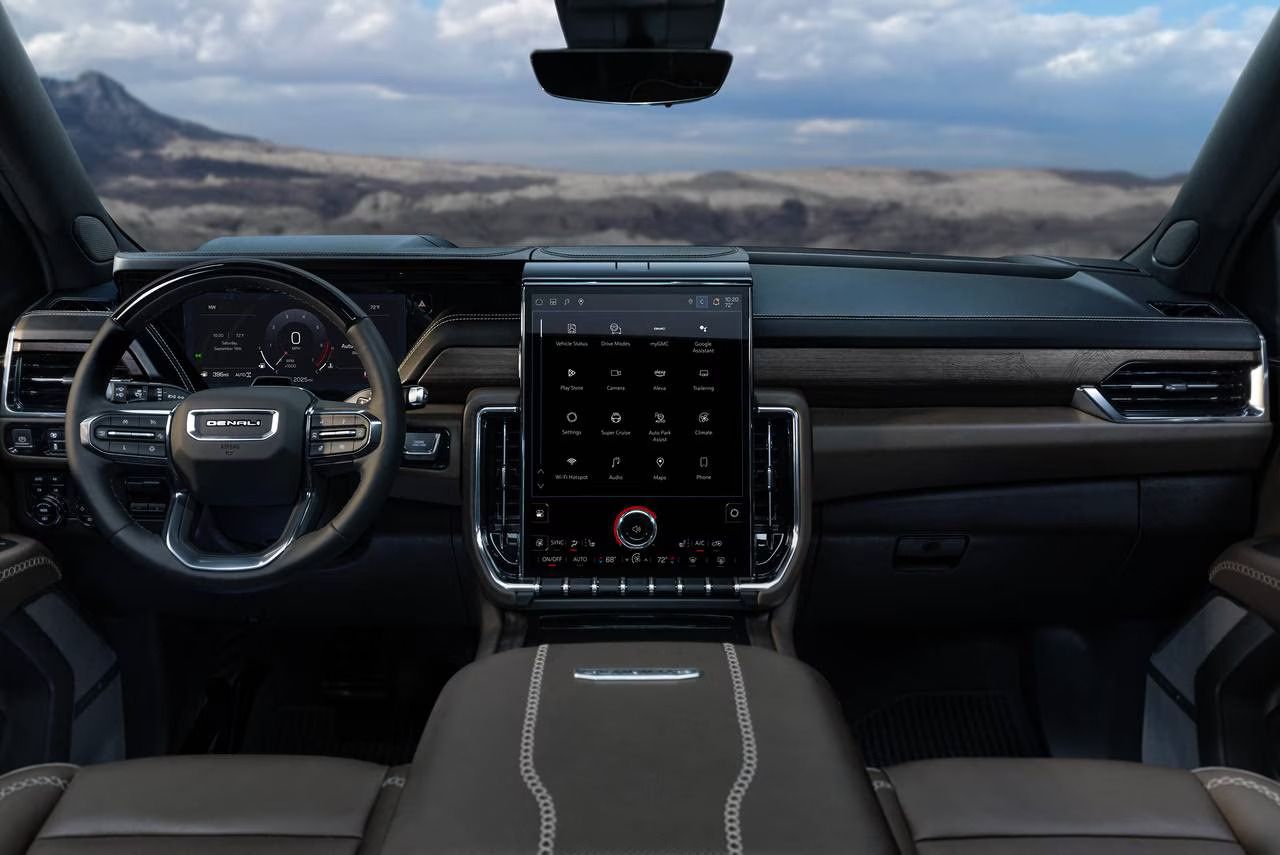View from inside a car with beige interior, steering wheel, and a rocky hillside outside the open door.