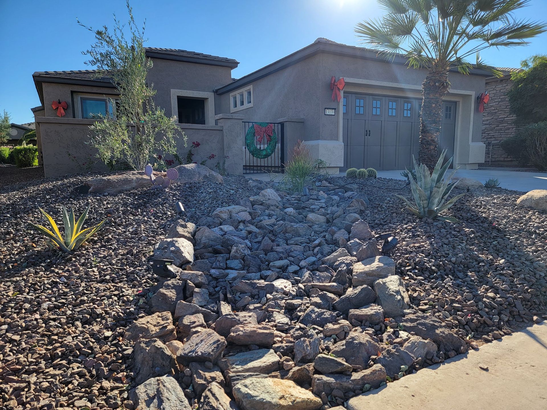 A house with a wreath on the garage door is decorated for christmas.
