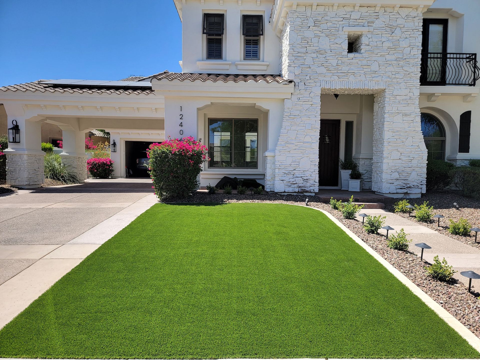 A large white house with a lush green lawn in front of it