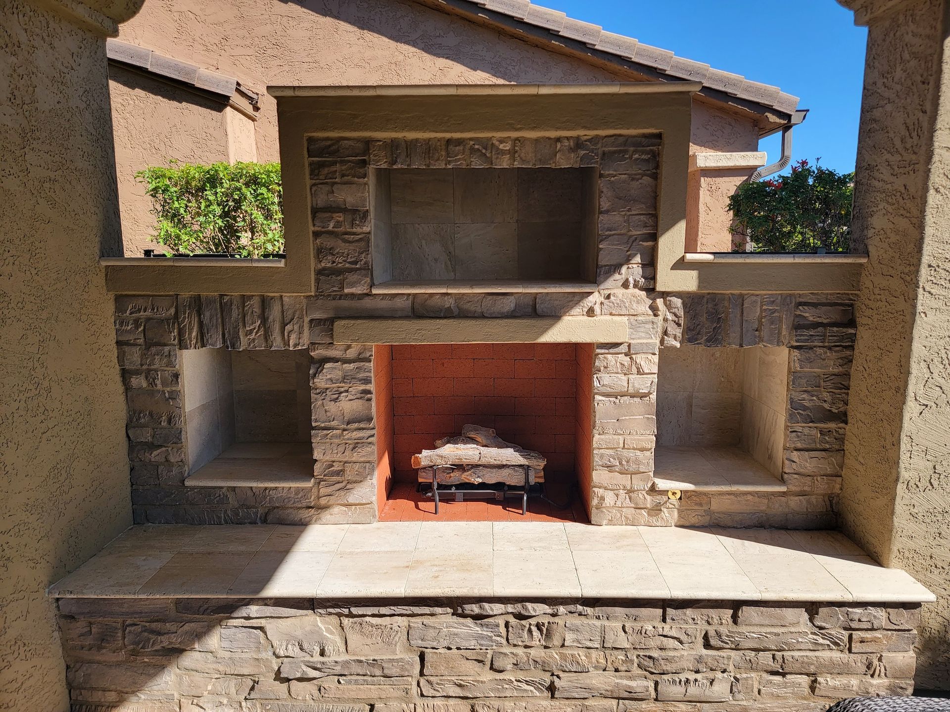 A brick fireplace is built into the side of a building.