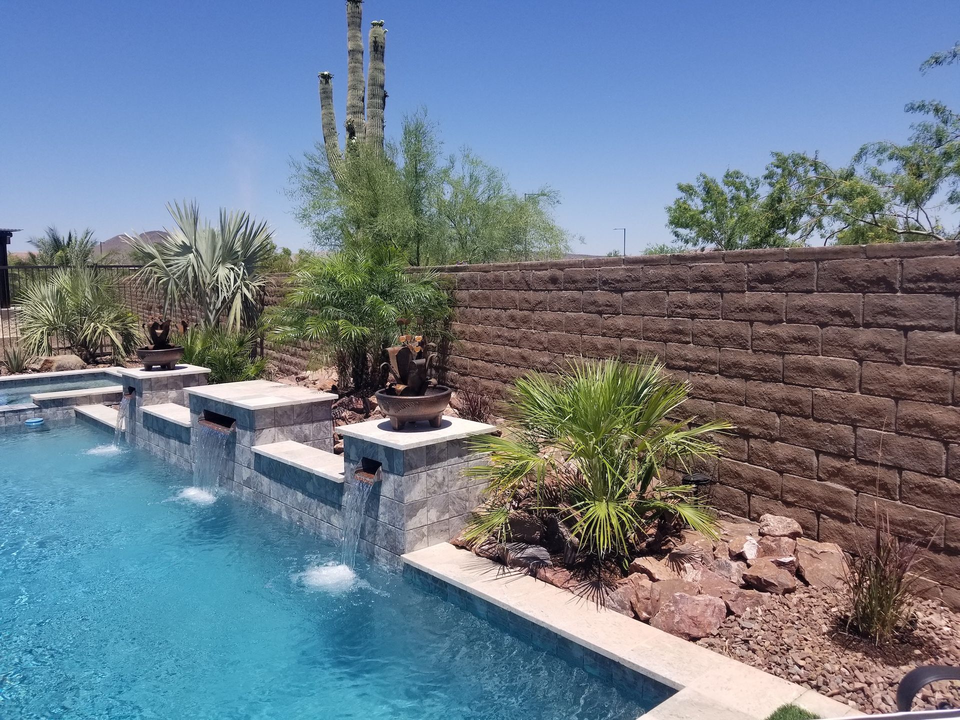 A large swimming pool with a brick wall surrounding it